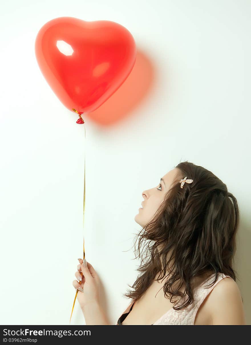 Photo of a young woman , holding red inflatable Valentines Day heart. Photo of a young woman , holding red inflatable Valentines Day heart.