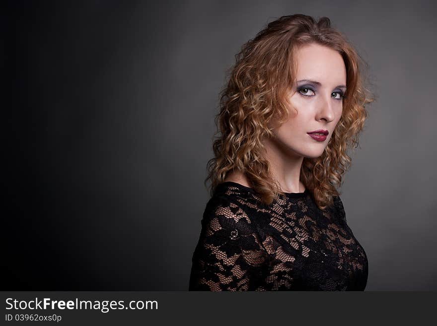 Young gorgeous model in a lace dress, a black background