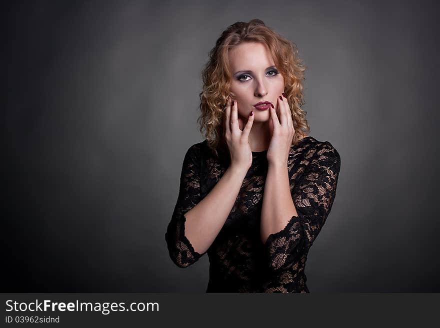 Portrait of a beautiful woman with hands near face