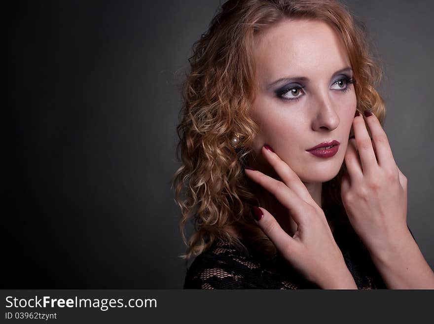 Portrait of a beautiful woman with hands near face