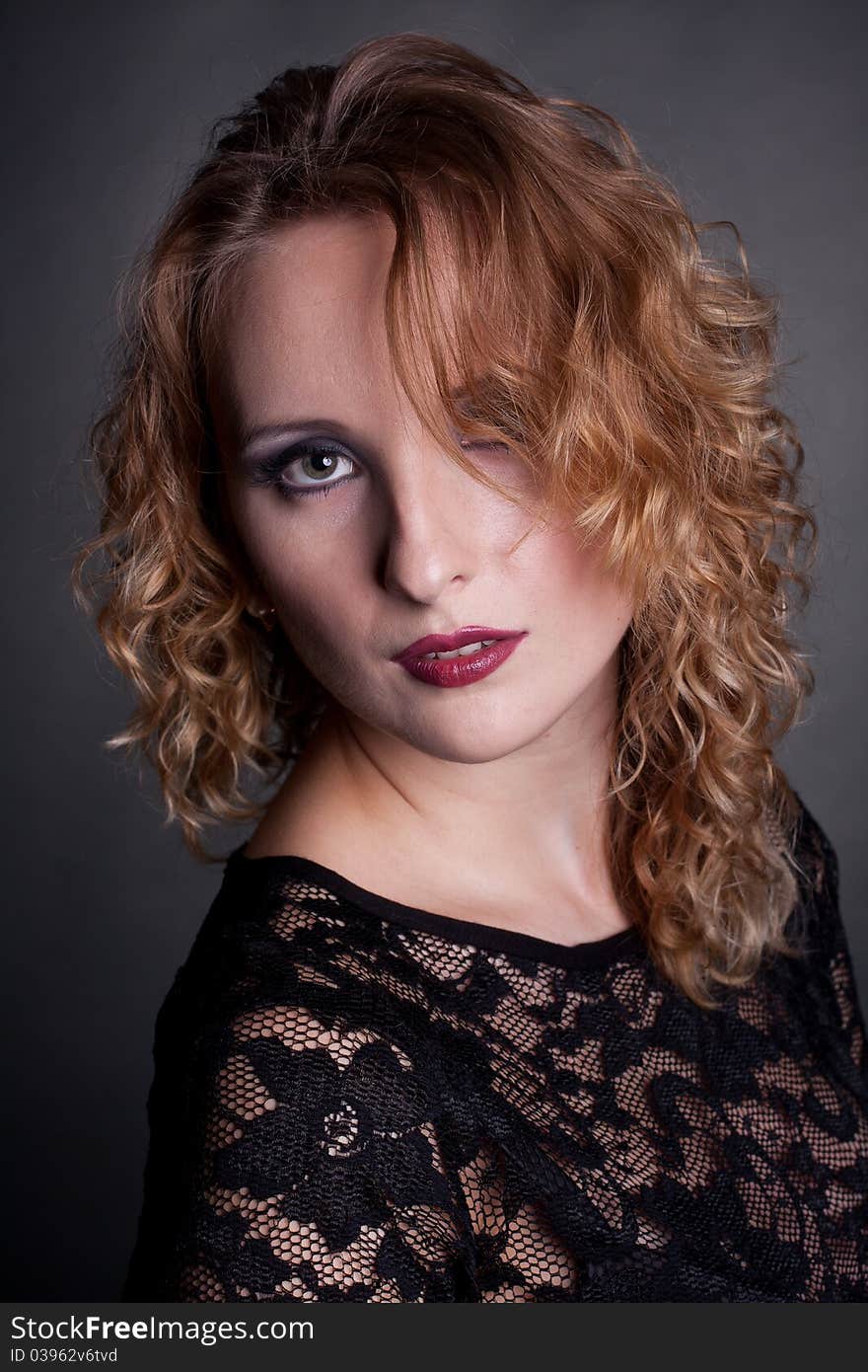 Young gorgeous model in a lace dress, a black background