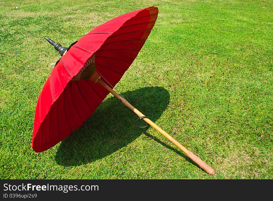 Red umbrella on the lawn chain mai style in thailand