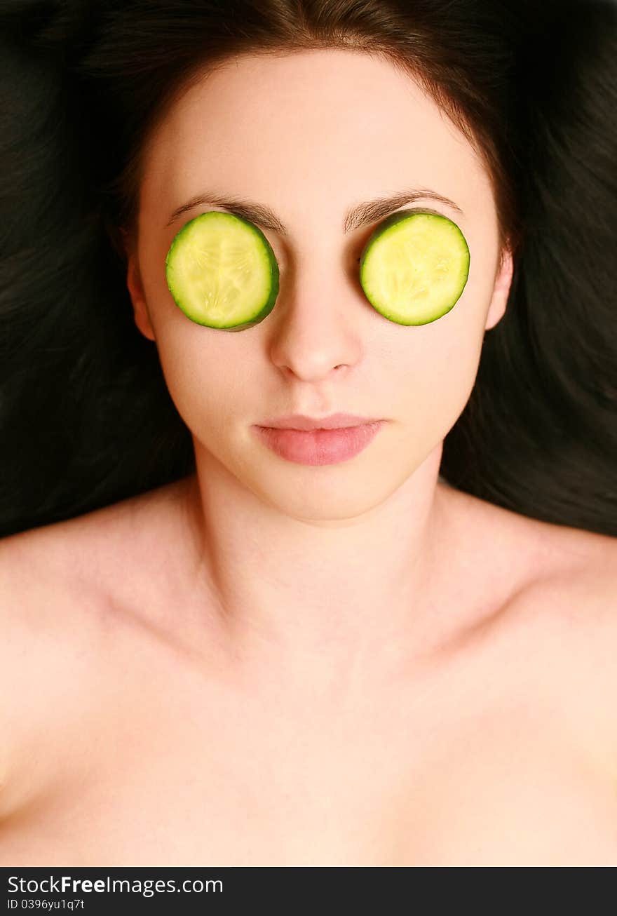 Beautiful young woman with a mask of cucumber on your face. Beautiful young woman with a mask of cucumber on your face