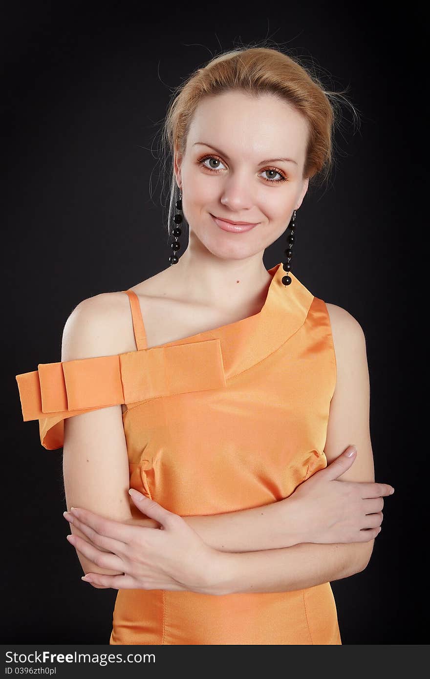 Fashion girl in orange dress on black background. Fashion girl in orange dress on black background