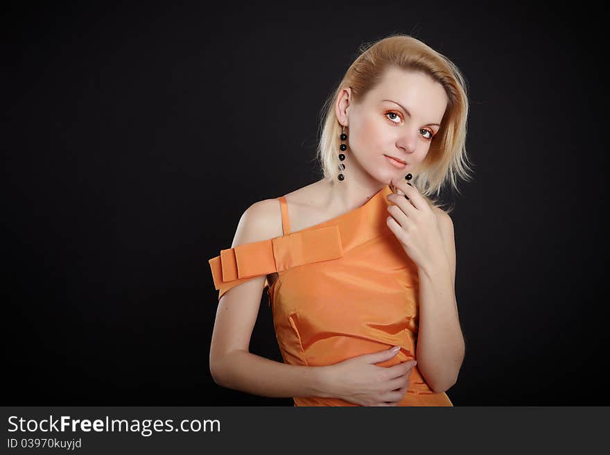 Fashion girl in orange dress on black background. Fashion girl in orange dress on black background