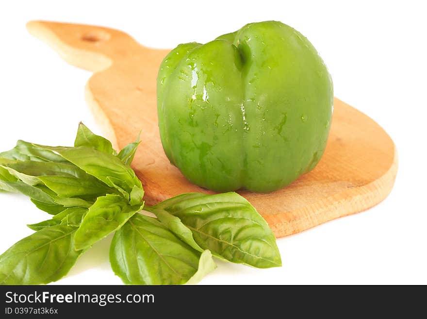 Fresh green pepper and basil on wooden board isolated on white background