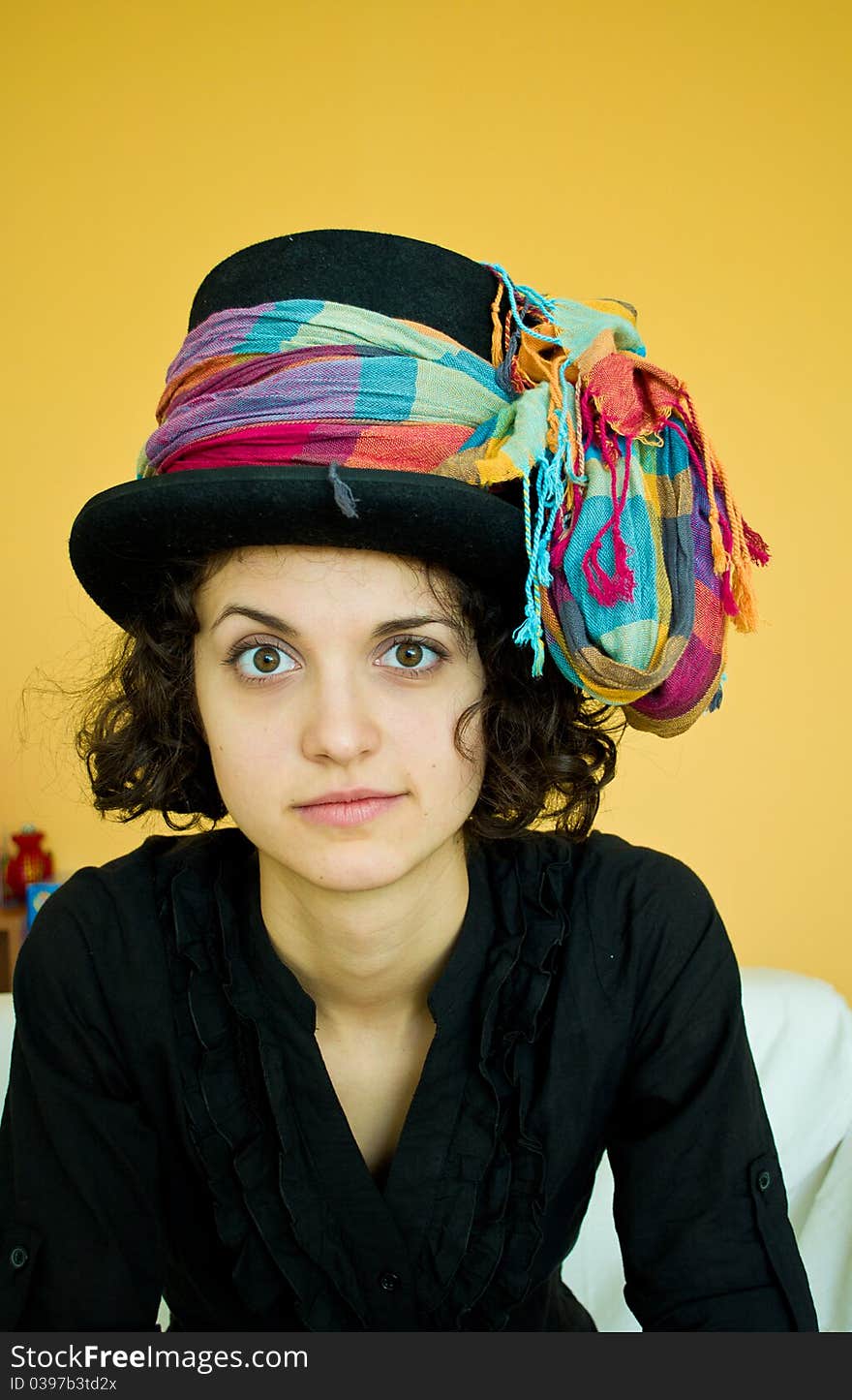 Portrait of a young woman with a black hat and a colorful scarf