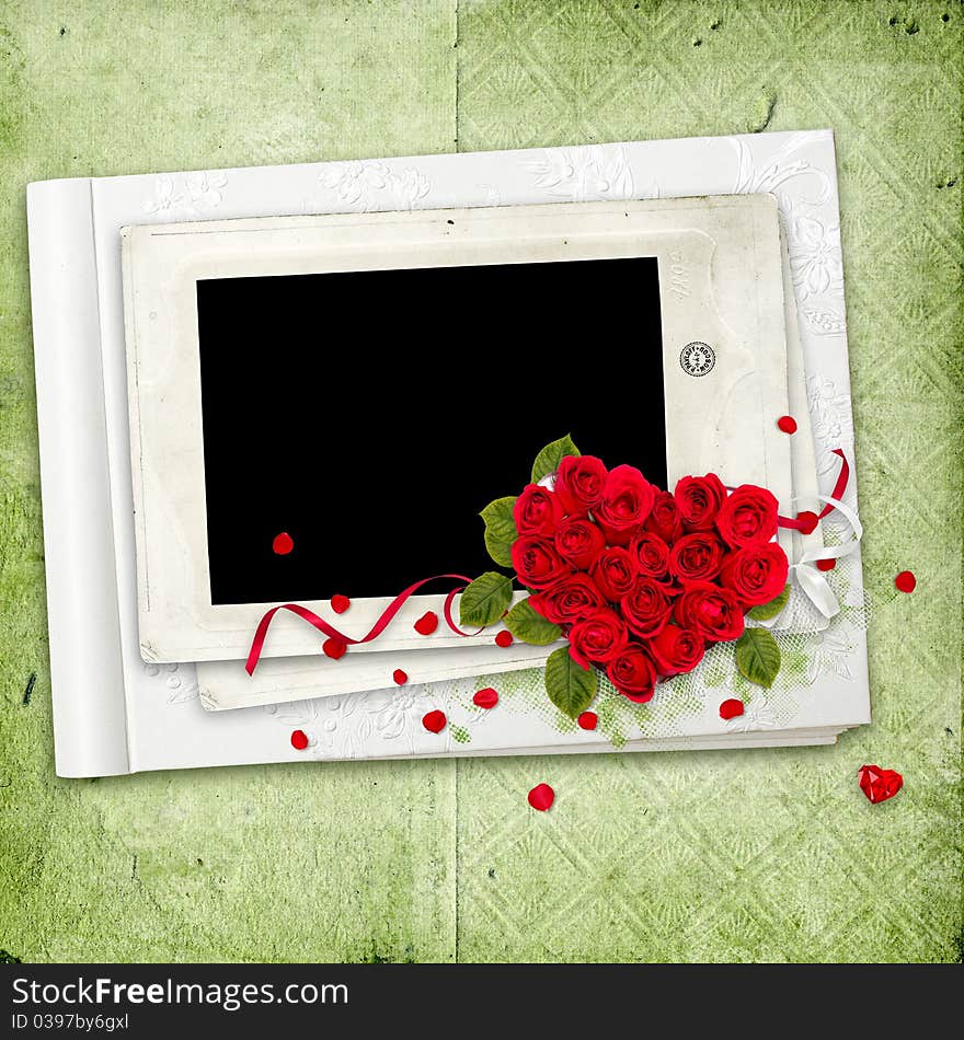 White album with red roses heart on the green