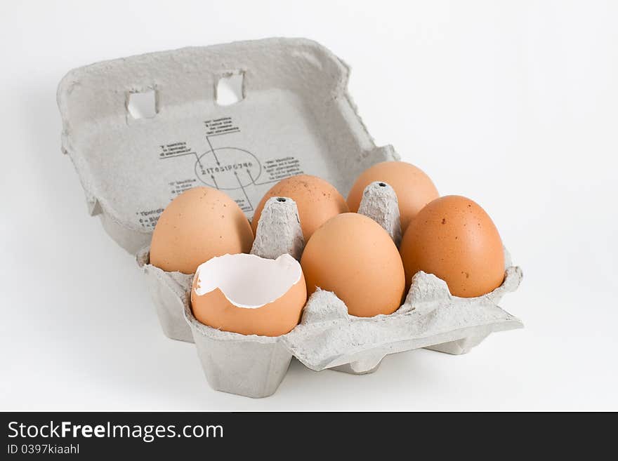 Six eggs in an egg-box isolated on a white background. Six eggs in an egg-box isolated on a white background