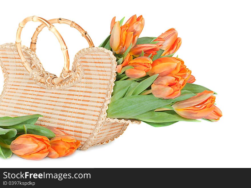 Tulips in the wicker handbag on a white background