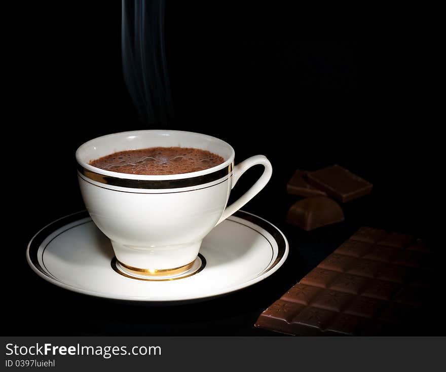 A cup of luxury chocolate drink & chocolate bar, on black background. A cup of luxury chocolate drink & chocolate bar, on black background