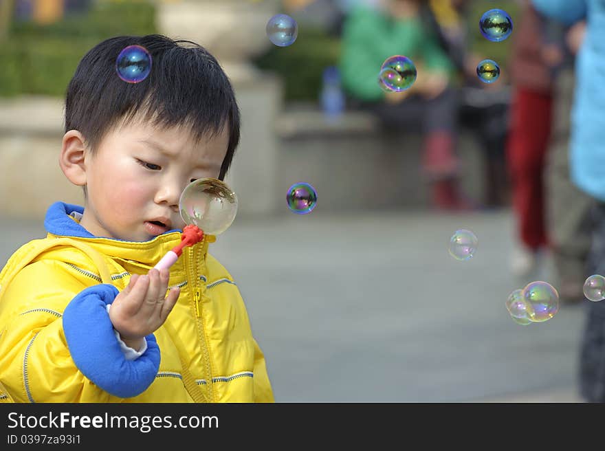 A cute child blowing soap bubbles. A cute child blowing soap bubbles