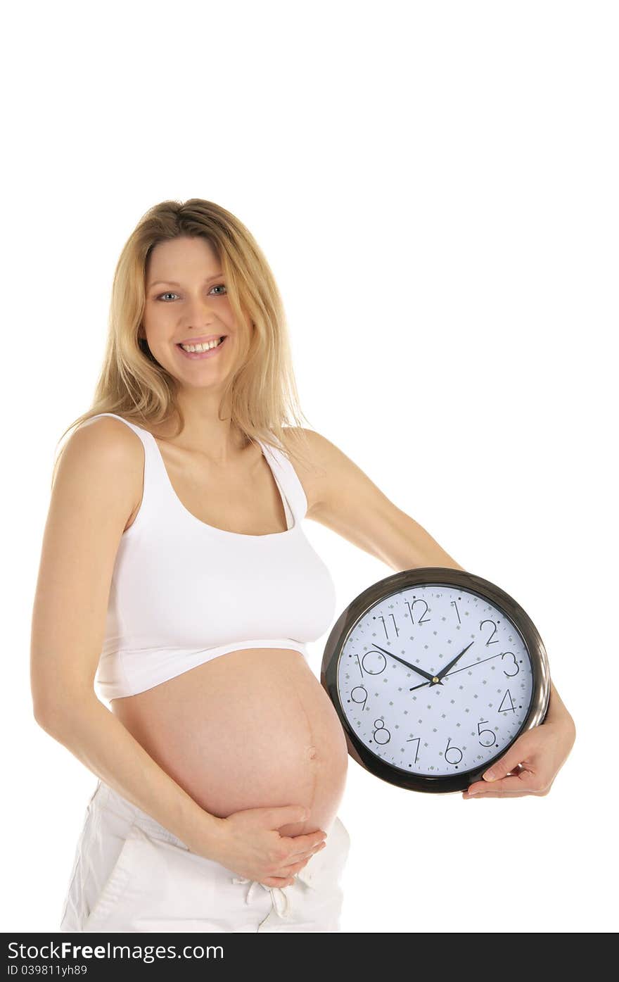 Happy pregnant woman with a round clock