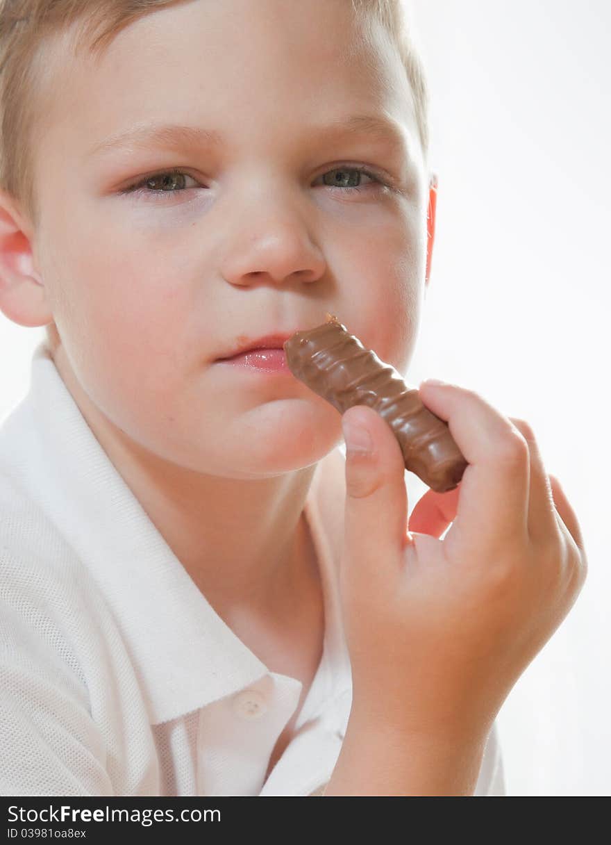 Portrait of a young boy eating chocolate bar,. Portrait of a young boy eating chocolate bar,