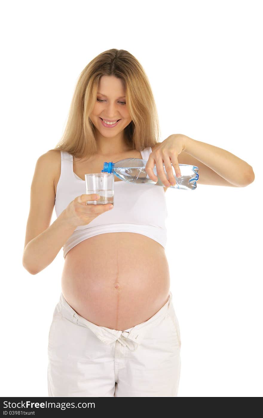 Pregnant woman pours water into a glass isolated on white