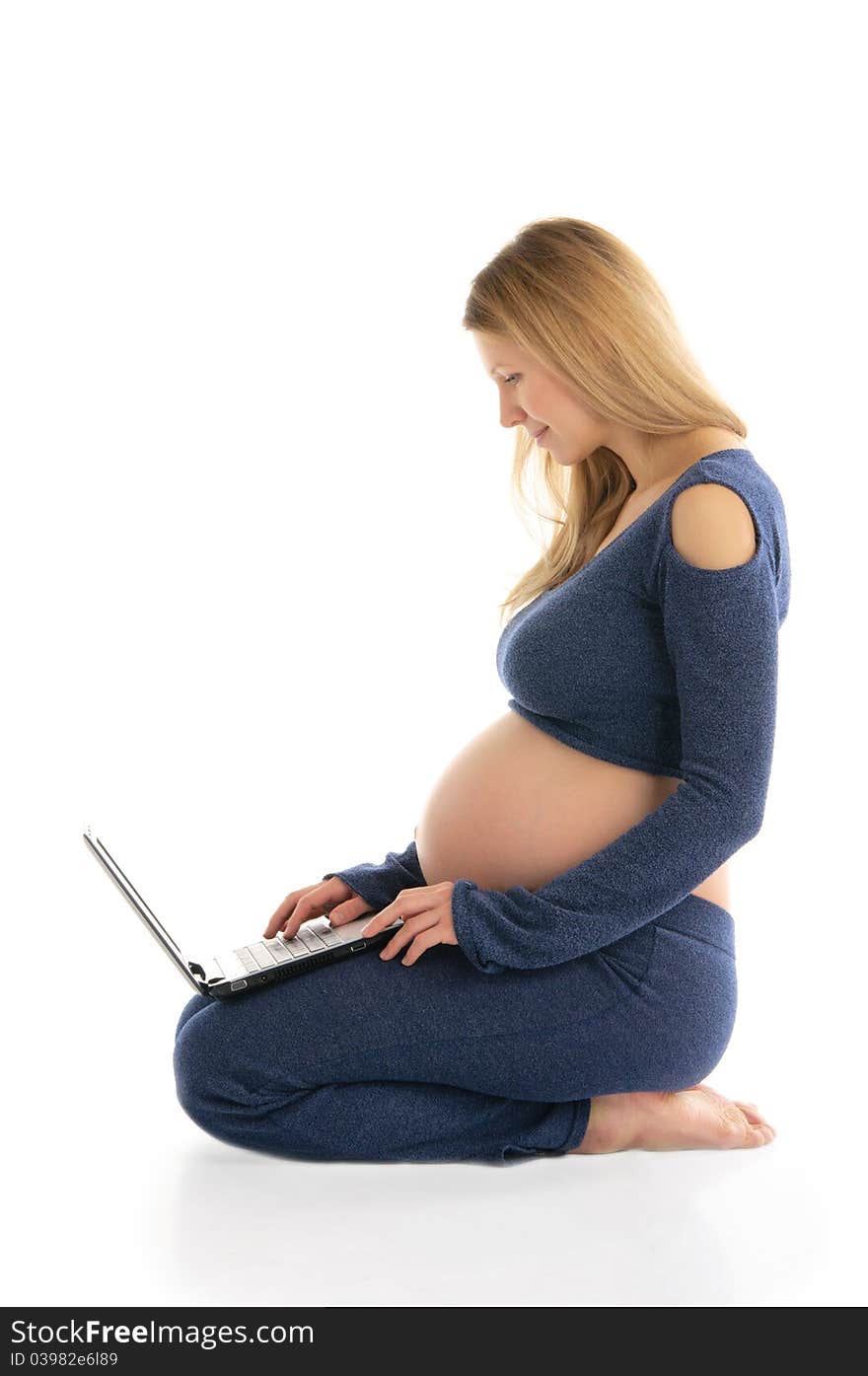 Pregnant Woman With A Laptop Sitting On The Floor