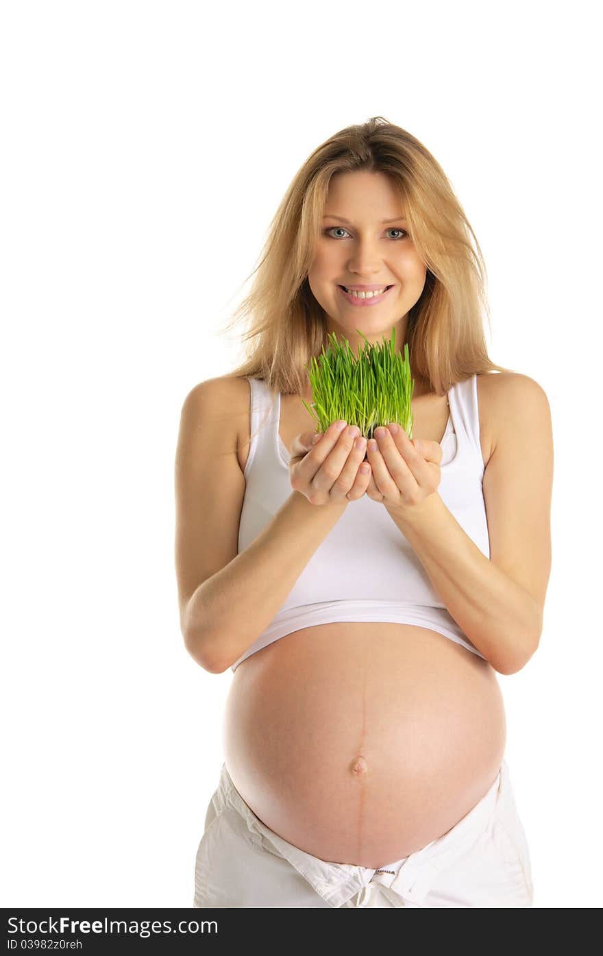 Pregnant woman holding green grass isolated on white