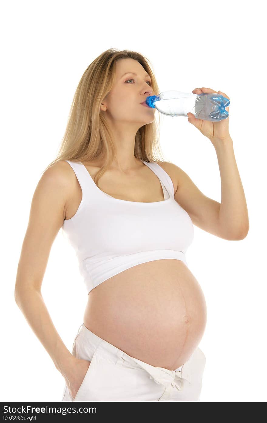 Pregnant woman drinks water from a bottle isolated on white