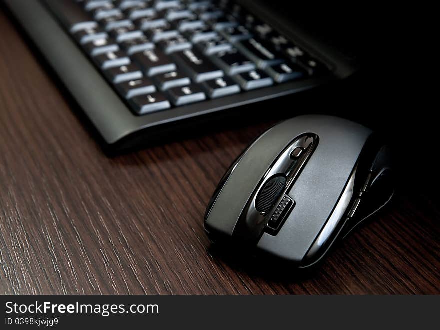 Black keyboard and mouse on a dark desk. Black keyboard and mouse on a dark desk.