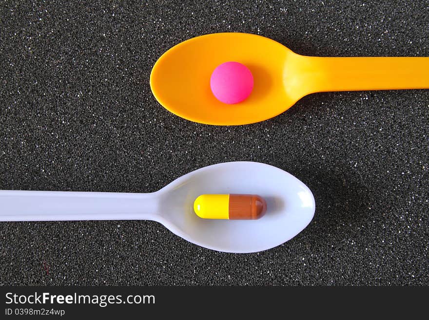 Spoonful Of Pills On Black Textile