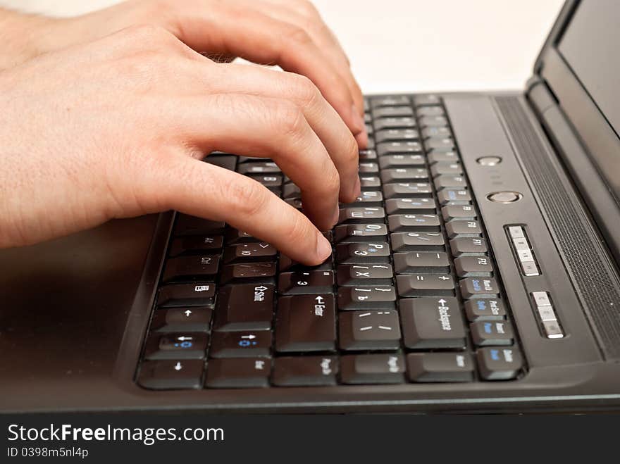 Male hands typing on a laptop keyboard. Male hands typing on a laptop keyboard