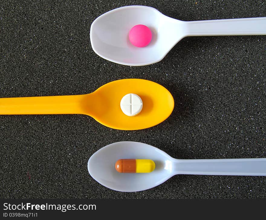 Spoonful Of Pills On Black Textile