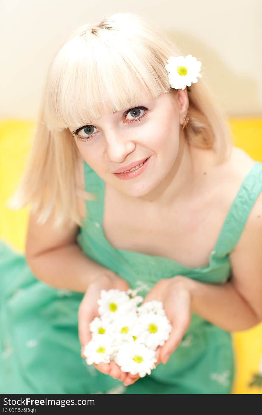 Good looking girl sitting with flowers