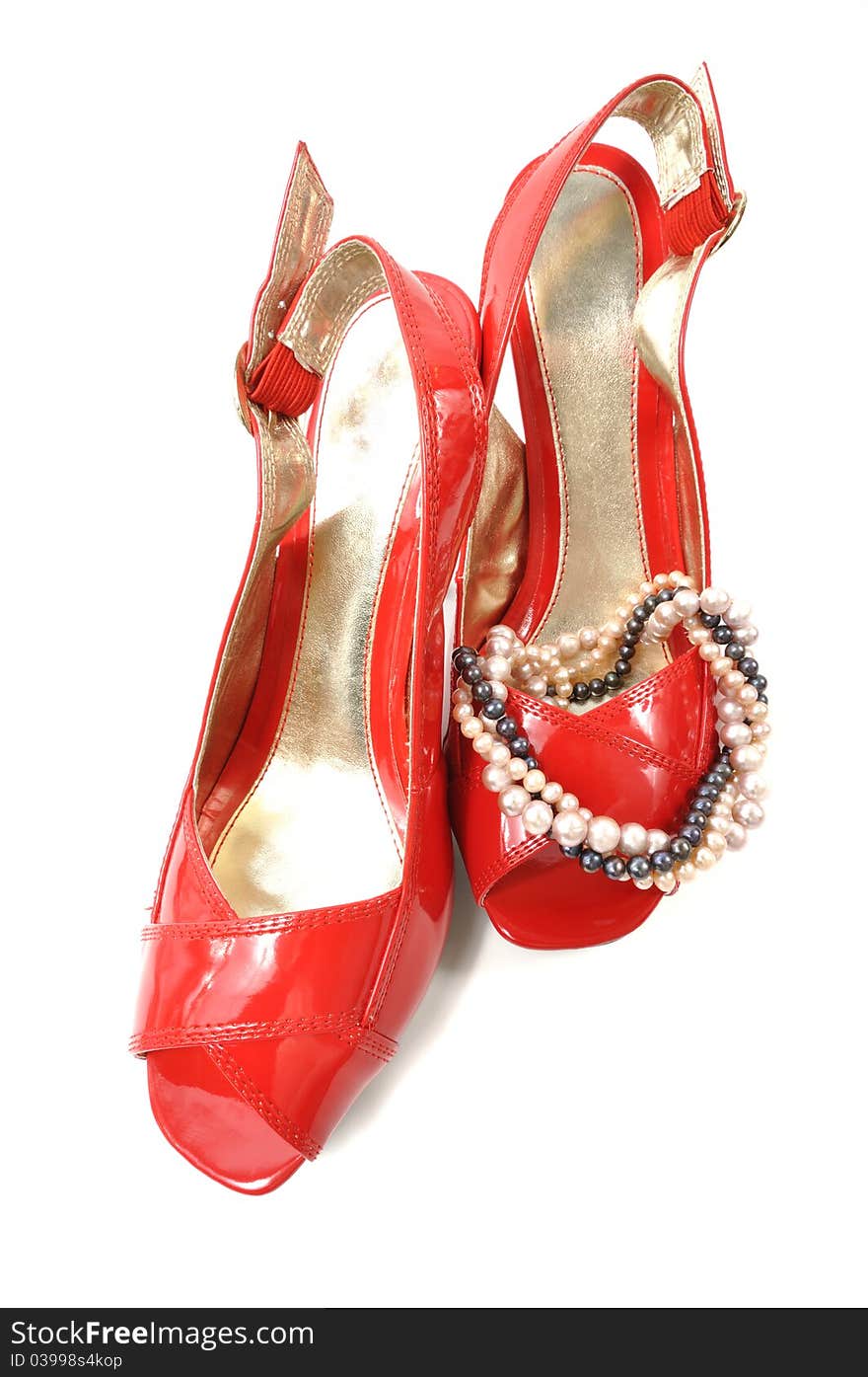 Woman red shoe with pearl necklace on a white background