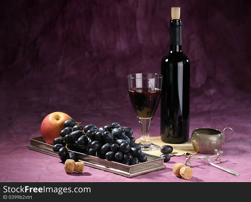 Still life with bottle of red vine and black grape on dark background. Still life with bottle of red vine and black grape on dark background