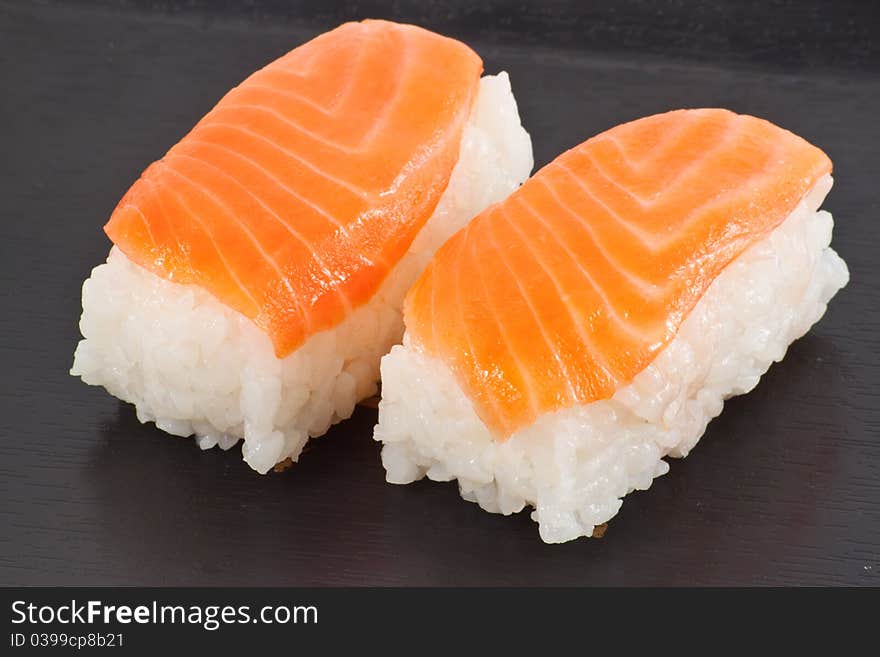 Salmon sushi on black plate