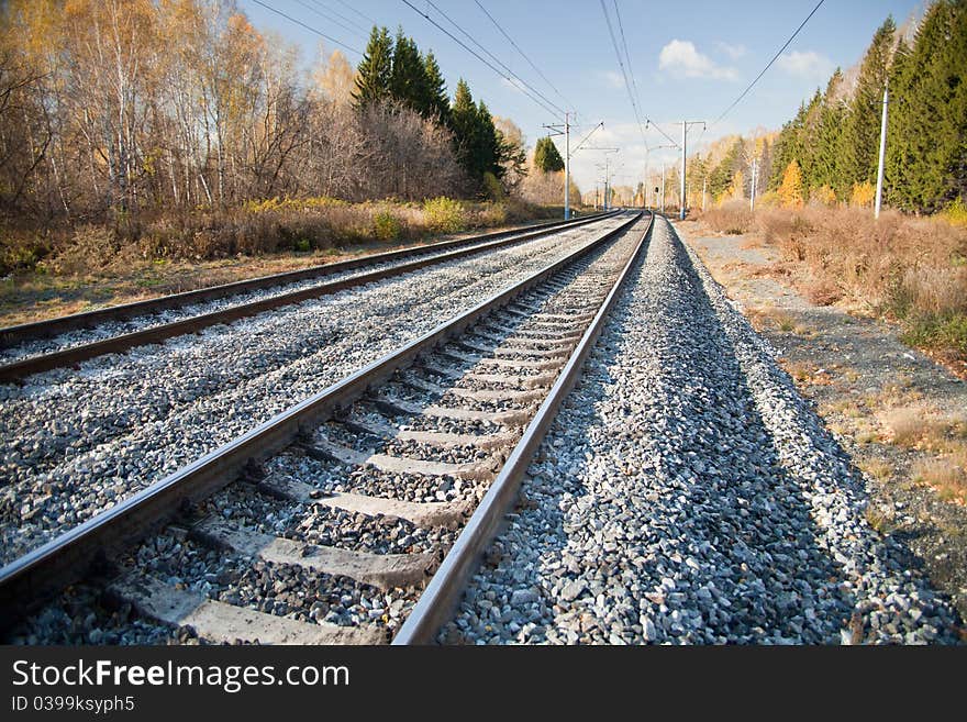 Railway tracks stretching into the distance, autumn landscape on both sides. Railway tracks stretching into the distance, autumn landscape on both sides