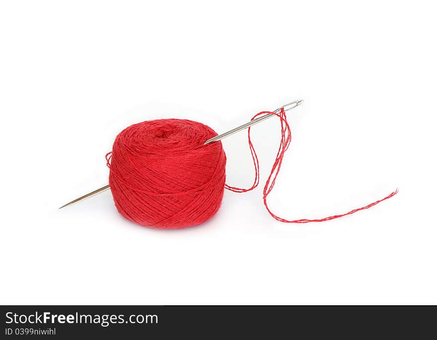 Clew Of Red Thread With Needle On White Background