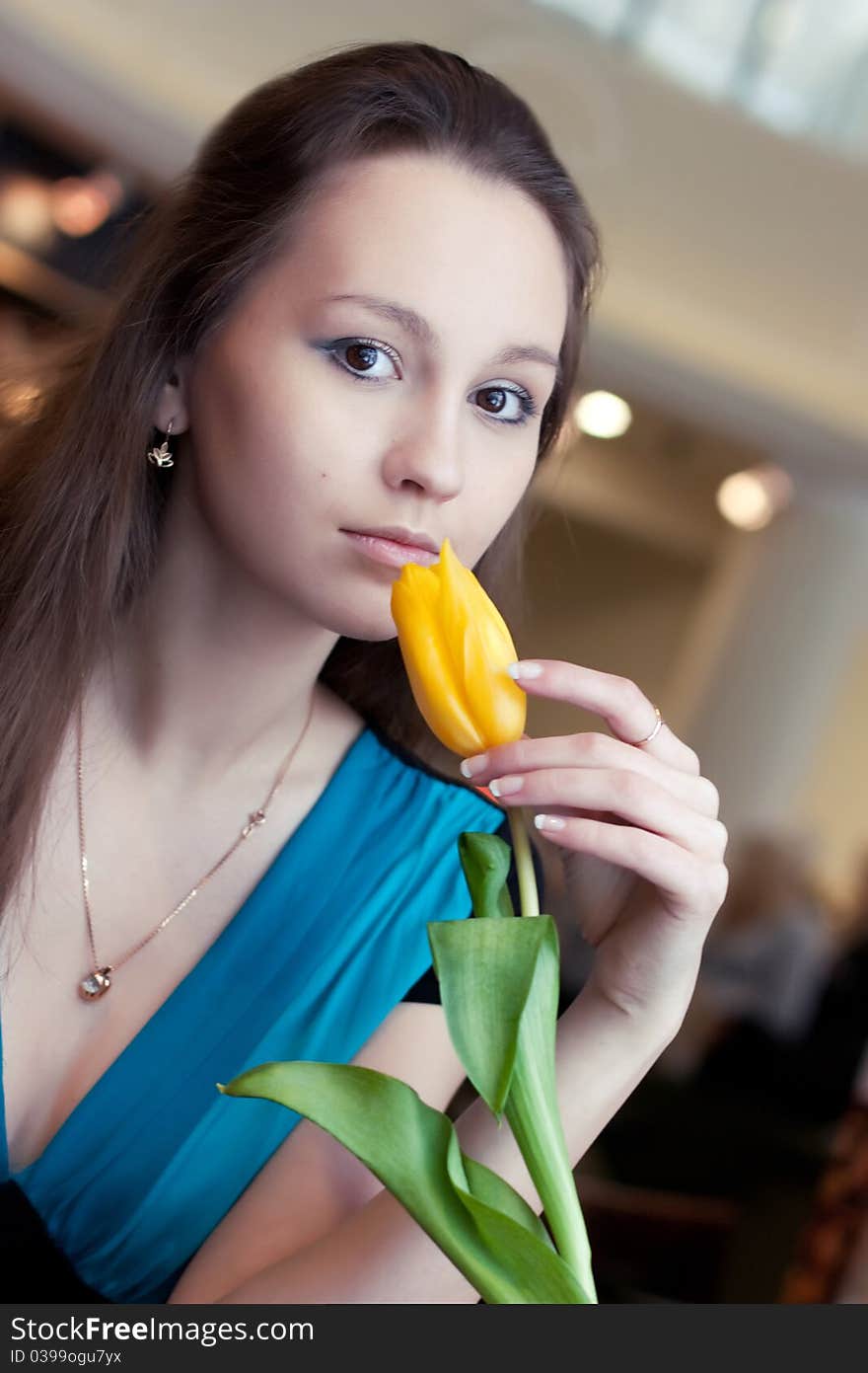 Girl with yellow tulip in cafe