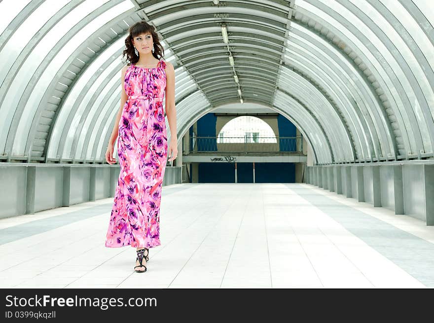 The girl in a long dress goes on a pedestrian crossing. The girl in a long dress goes on a pedestrian crossing