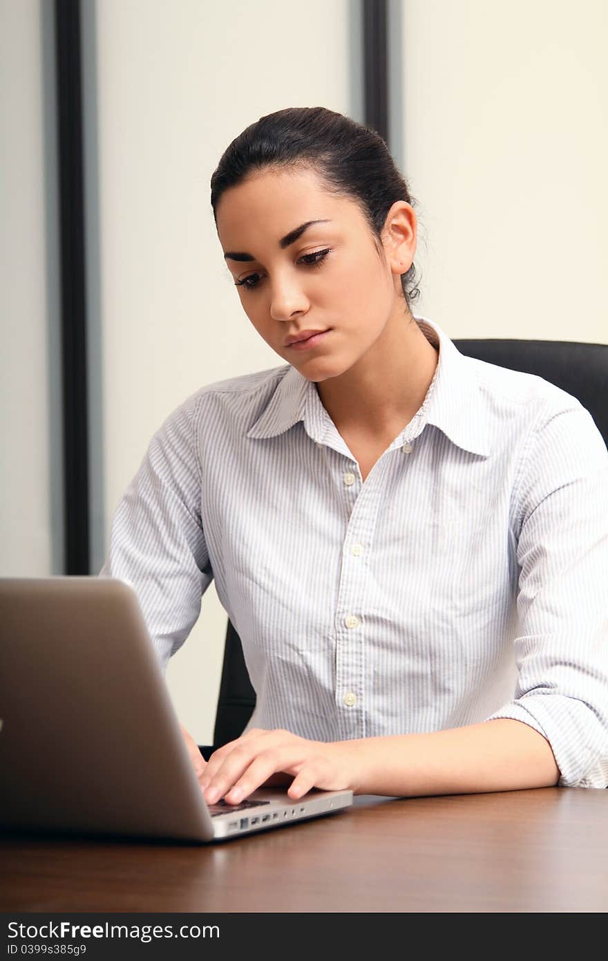 Beautiful brunette young business woman working with her laptop