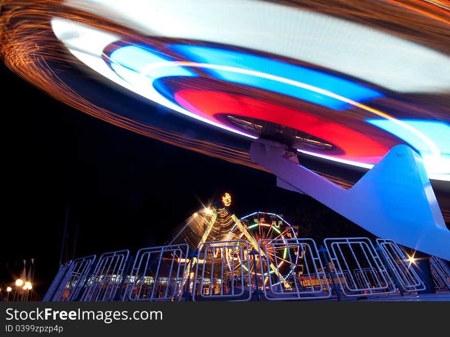 Festive mood and movement at night in an amusement park. Festive mood and movement at night in an amusement park