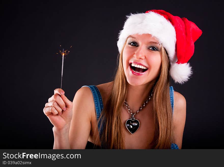 Cute girl in Santa hat holding sparklers. Cute girl in Santa hat holding sparklers