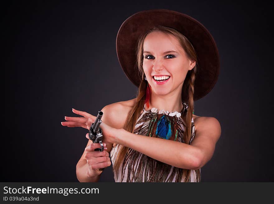 The American Indian girl in a cowboy's hat holds a pistol