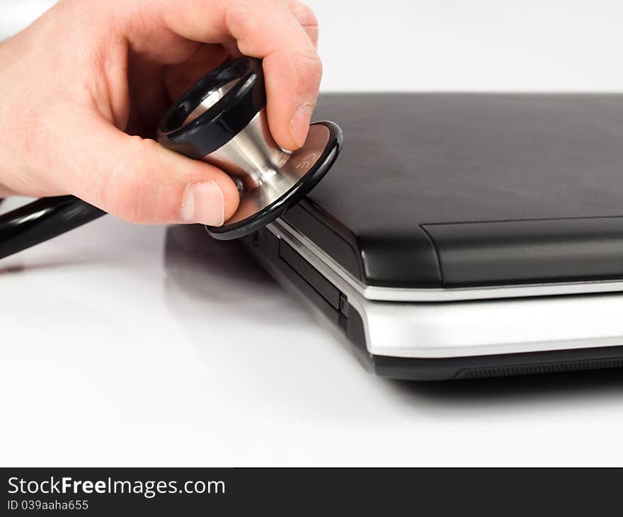 Hand with medical stethoscope diagnosing a notebook. Hand with medical stethoscope diagnosing a notebook.