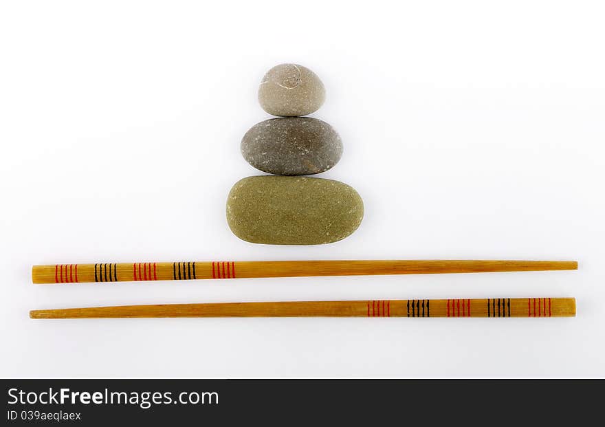 Chopsticks and stones isolated on white background