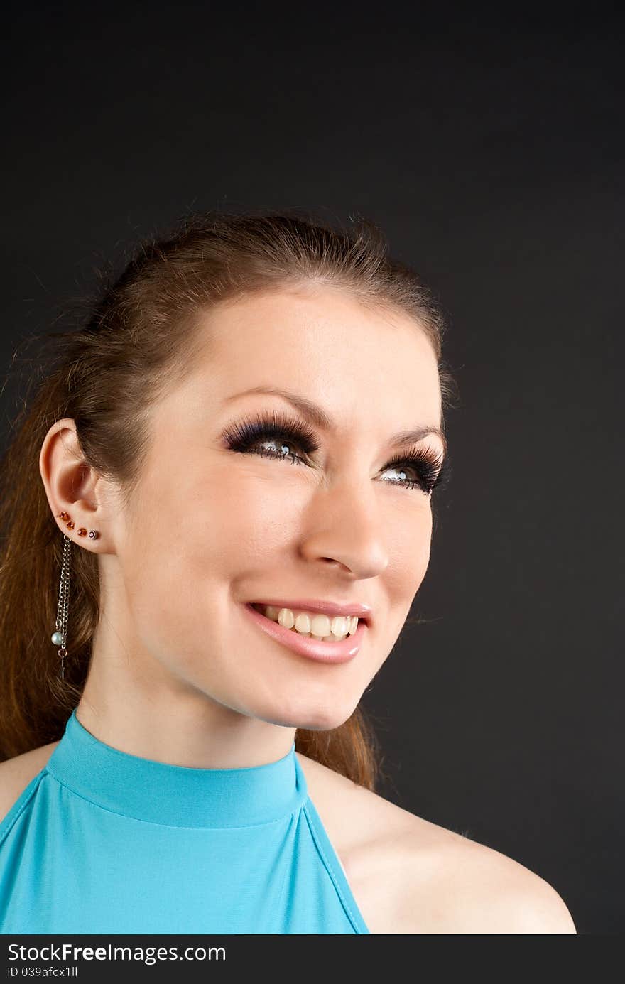 The beautiful smiling girl on a black background