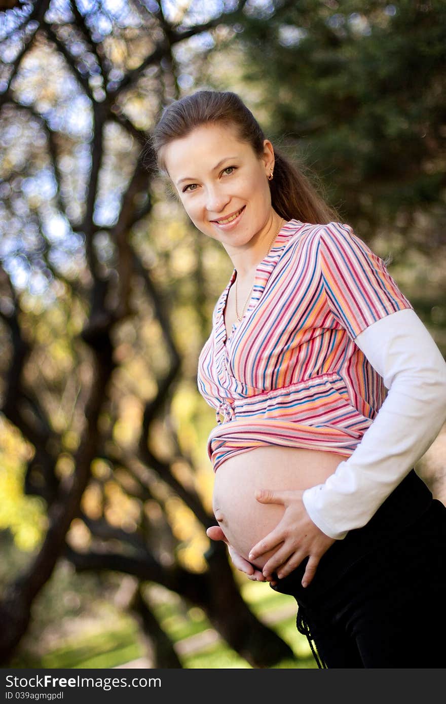 Beautiful pregnant woman relaxing in the park