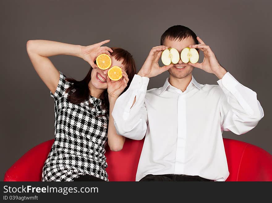 Funny couple shutting eyes with apple and orange