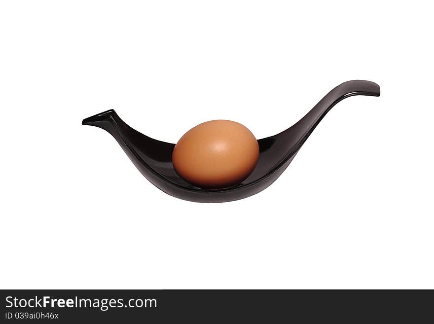 Beige Egg On A Black Plastic Plate In Form Of Bird