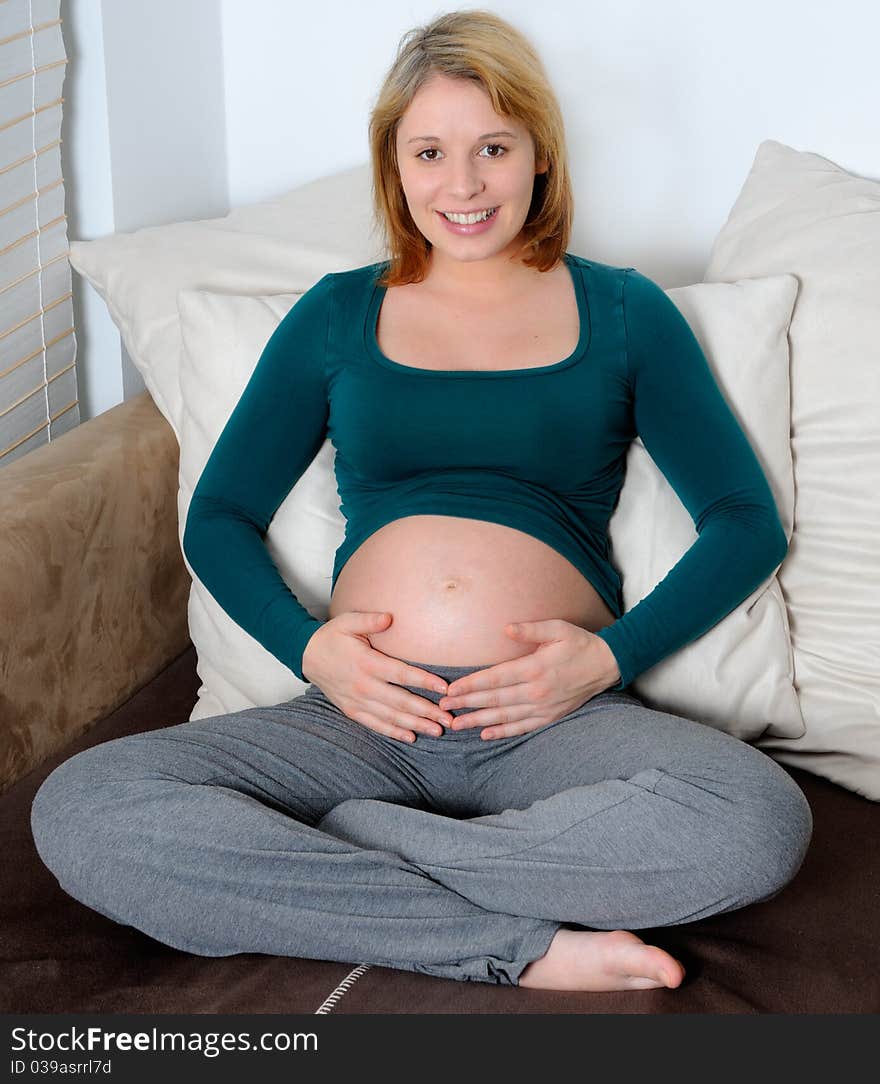 Young pregnant woman with hands on her abdomen.