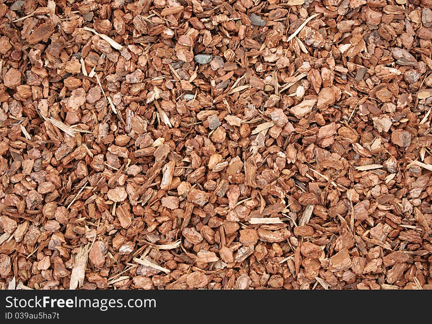 Closeup of red wood chip mulch used to control weeds on flower and vegetable beds. Closeup of red wood chip mulch used to control weeds on flower and vegetable beds