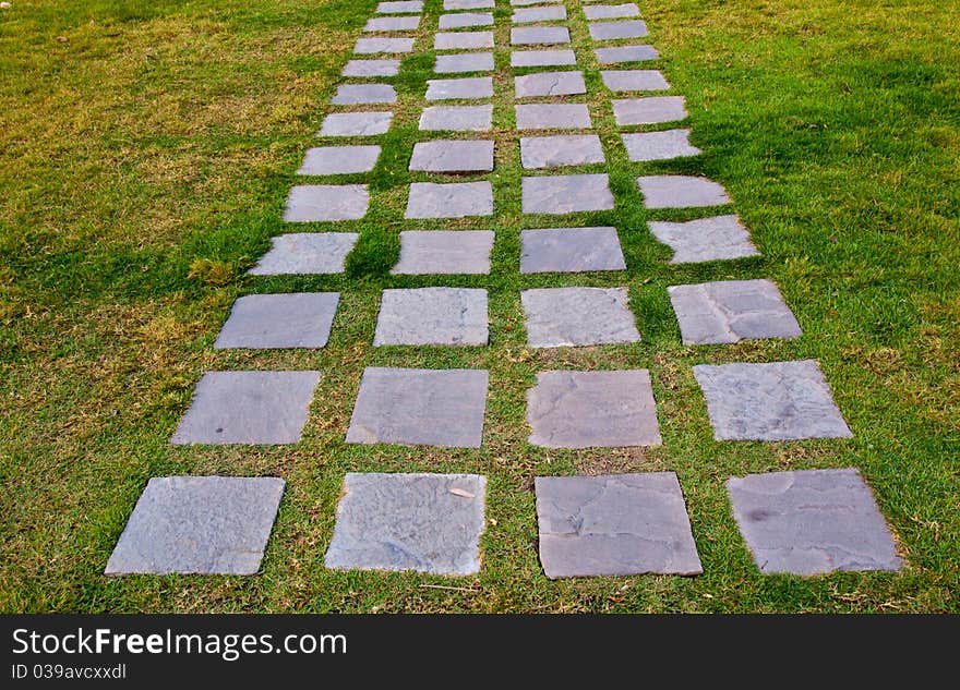 Clay walk path near the lake with green trees