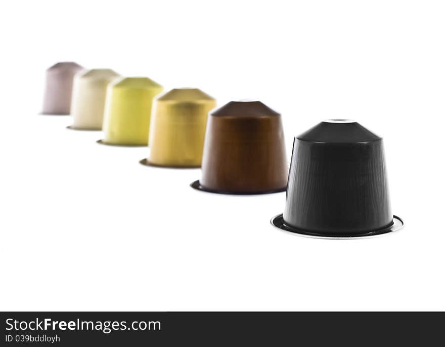 Coffee capsules line with different colors isolated on white