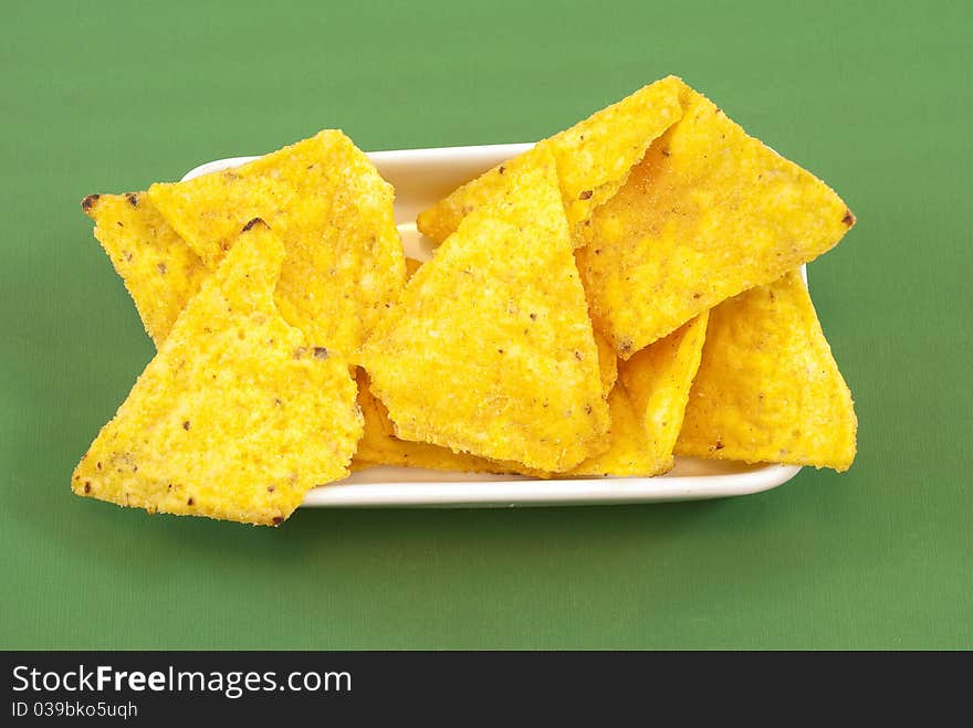 Mexican chips in the foreground on a green background. Mexican chips in the foreground on a green background