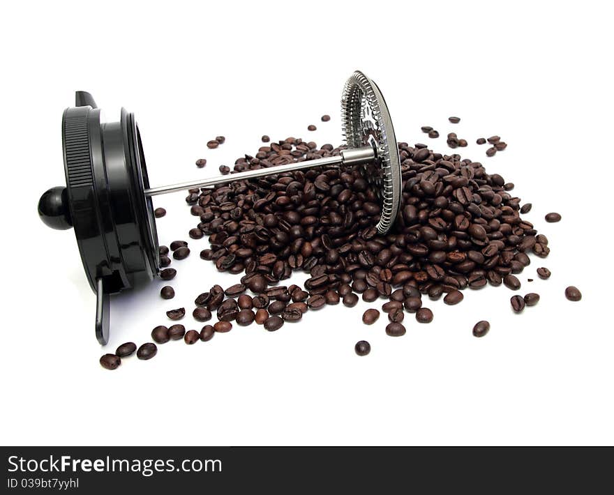 A piece of bod-um coffee machine lying on a pile of coffee beans. A piece of bod-um coffee machine lying on a pile of coffee beans